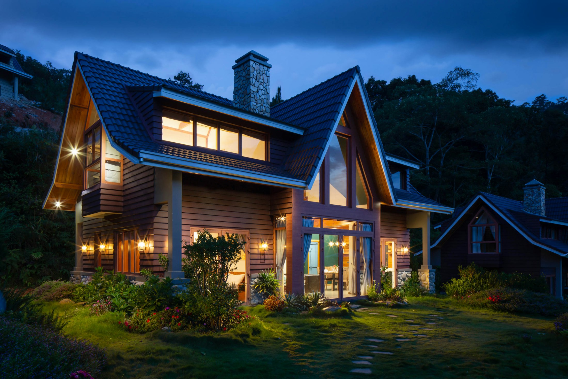 Detached family home at dusk with warm lights in the windows