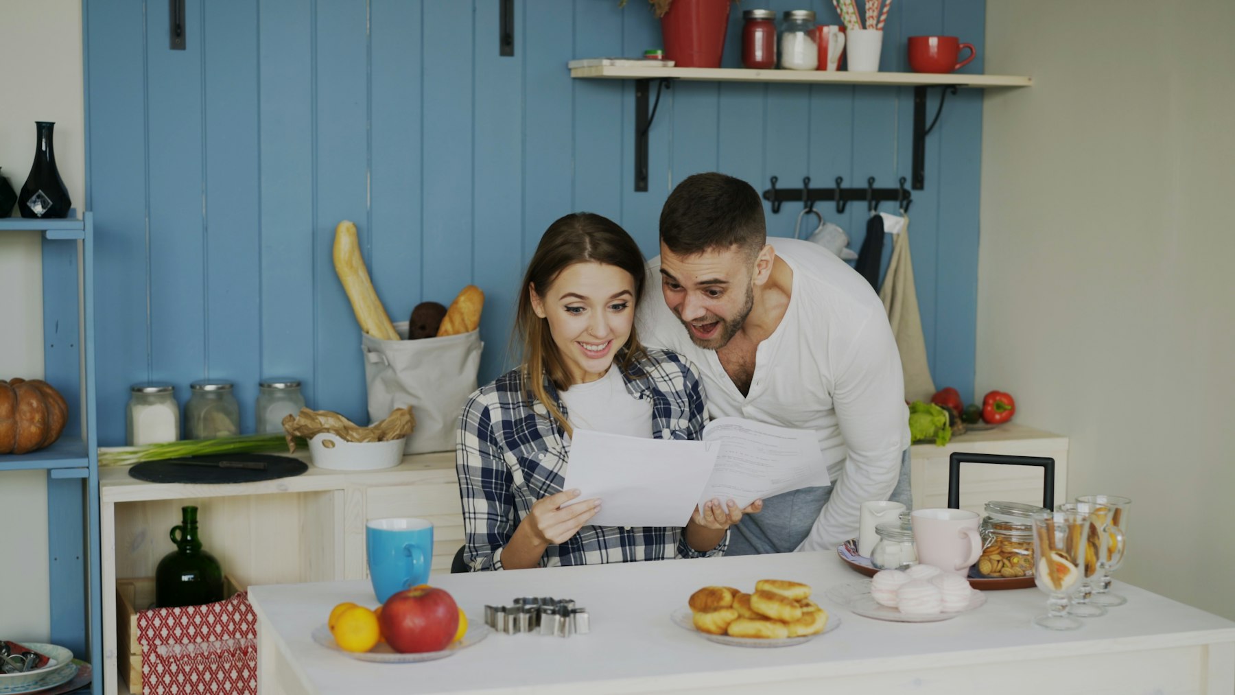 Couple reviewing mortgage paperwork at the kitchen table